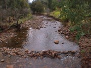 A walk bridge crosses the river towards the ruins