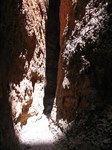 Shaft of sunlight illuminating conglomerate rock inside chasm