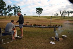 the hunters preparing the redclaw, watched by parrots