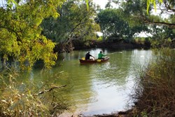 the canoe and men on the water at hookeys waterhole