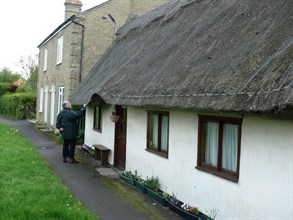 Cottages with thatched roofs, low eaves and doors.