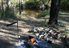 campfire and creek in background