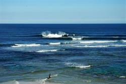 surfers catch a wave near Margaret River mouth